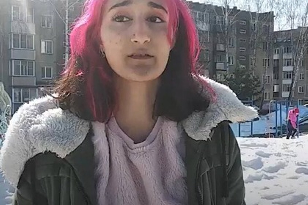 Девушка с розовыми волосами на улице стоит в куртке