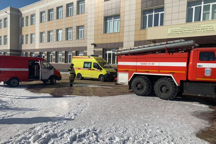Желтая машина скорой помощи и красная пожарная машина стоят на улице около трехэтажного здания