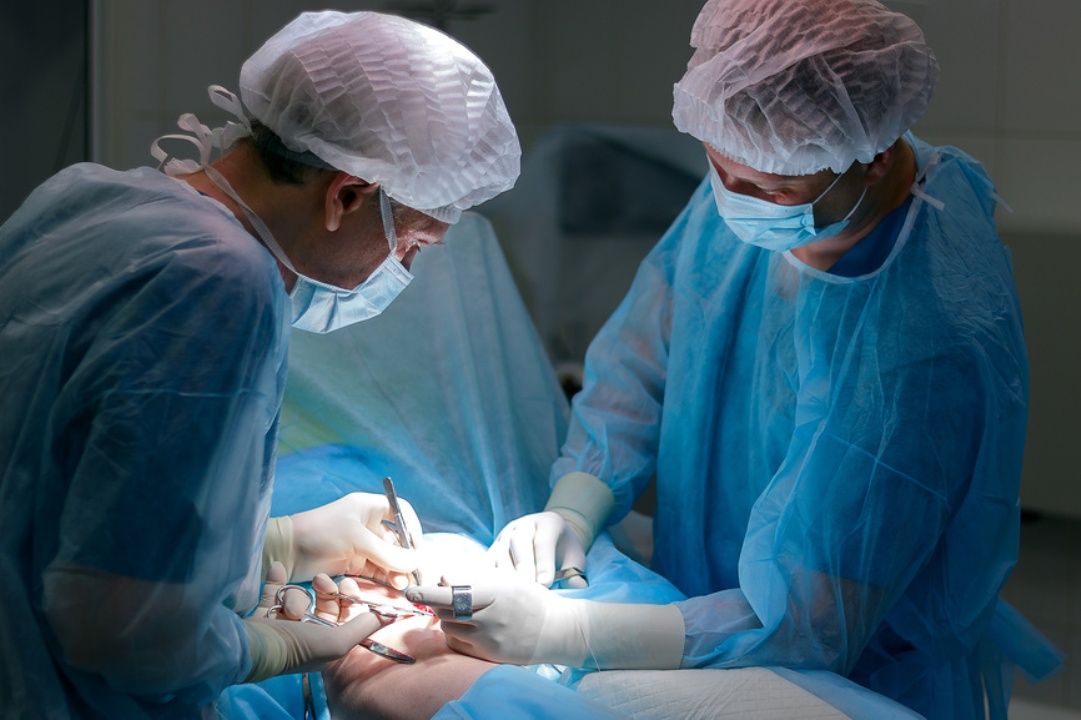 Хирурги в синих халатах делают операцию