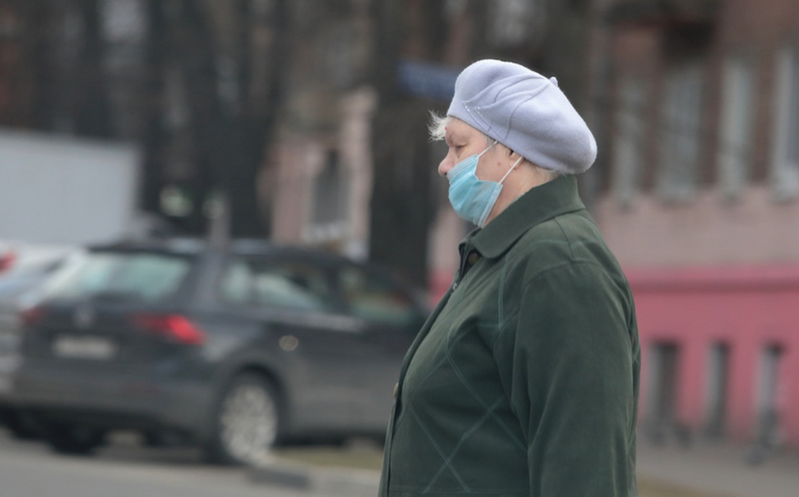Женщина идет по улице в маске