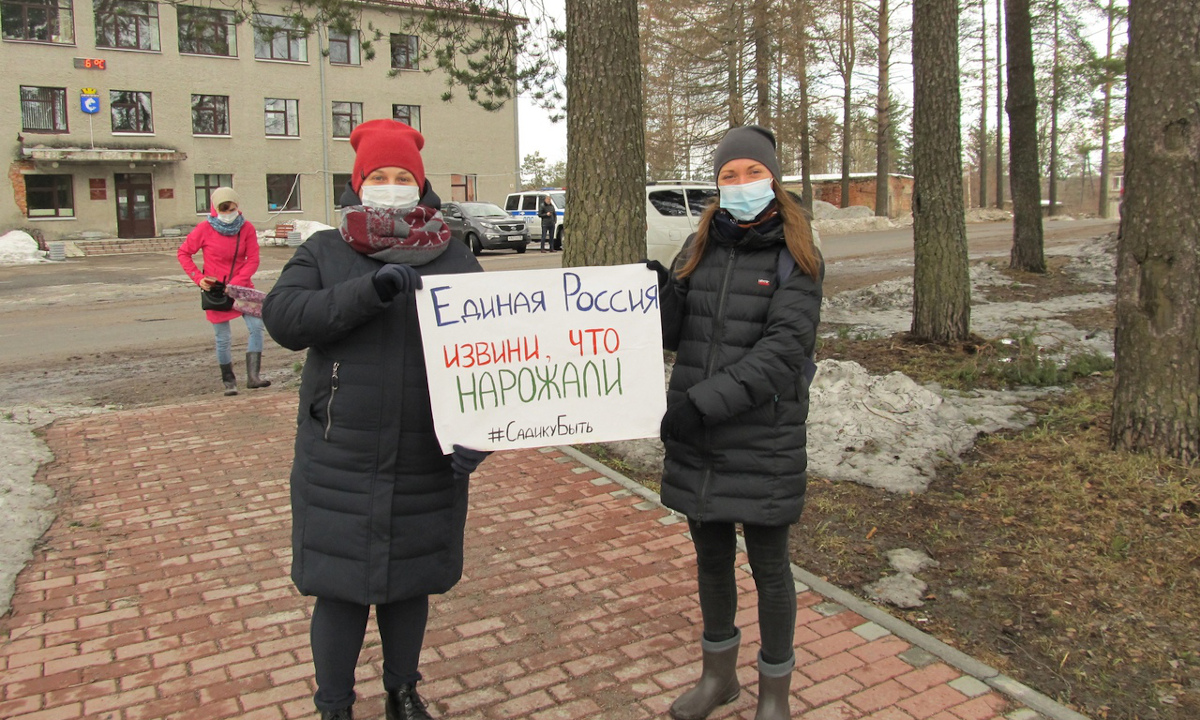 Девушки с плакатом на митинге