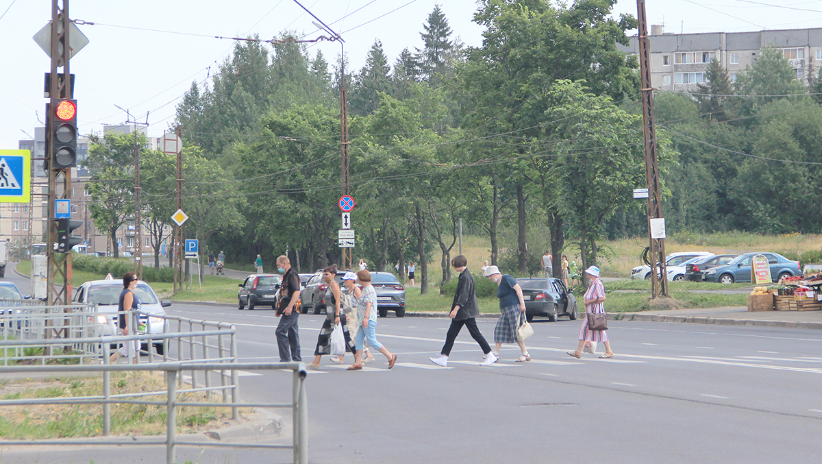 Люди переходят дорогу по пешеходному переходу